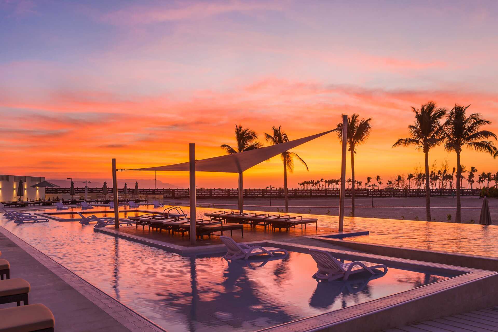 Poolen og smuk solnedgang på Fanar Hotel & Residences i Salalah, Oman.